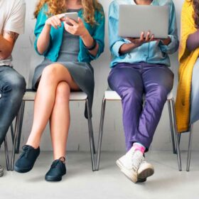 new community features for potography members - 2023-community-updates-image of diverse group of human sitting in charis alongside a wall, visible from neck down, all using electronic devices--AdobeStock_106541505